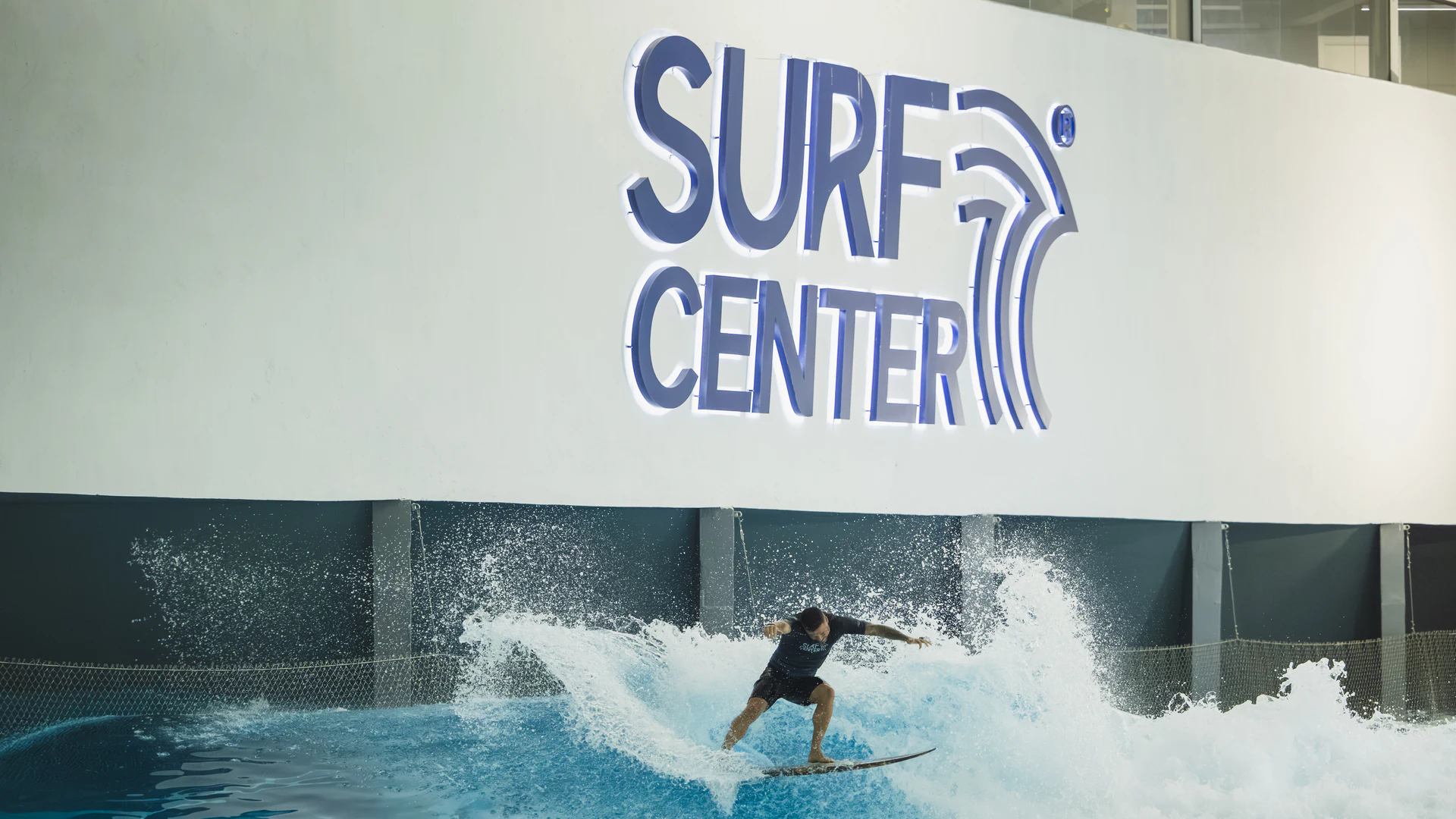 Surfista pegando onda na piscina de ondas indoor da Surf Center Curitiba, clube de surf no bairro Orleans